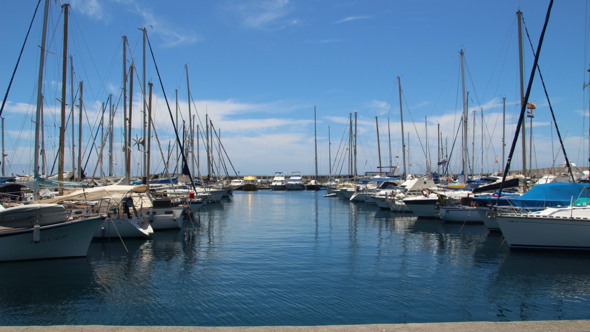 Fischerboote und Yachten im Hafen unter strahlend blauem Himmel – maritimes Flair wie an der Küste von Arrecife, Lanzarote