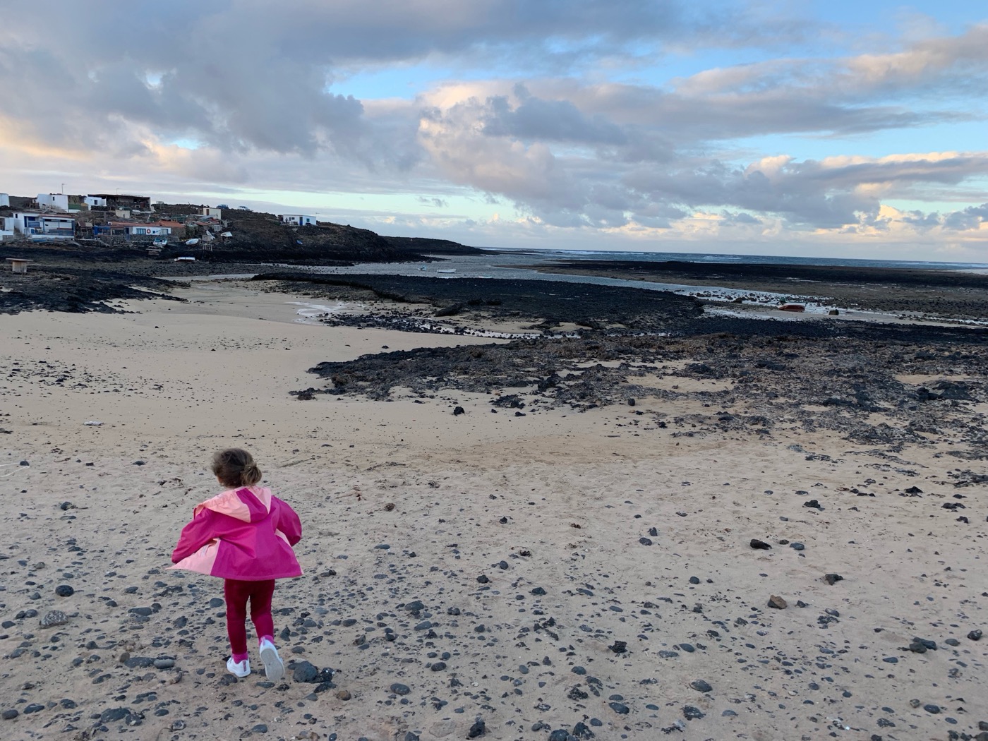 Kind läuft am schwarzen Lavastrand auf Lanzarote – Familienurlaub auf der Vulkaninsel