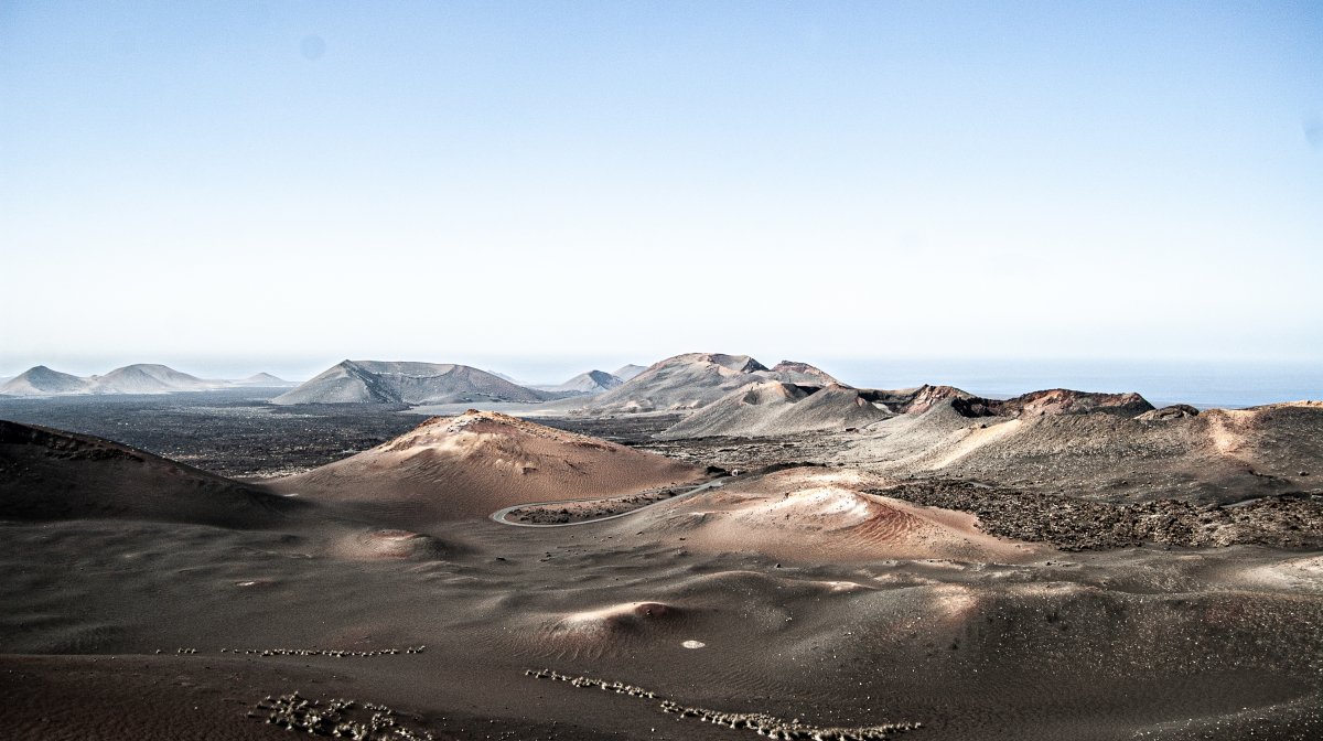 Lanzarote aus der Luft – die schwarze Vulkanlandschaft der Insel mit Kratern und roter Erde