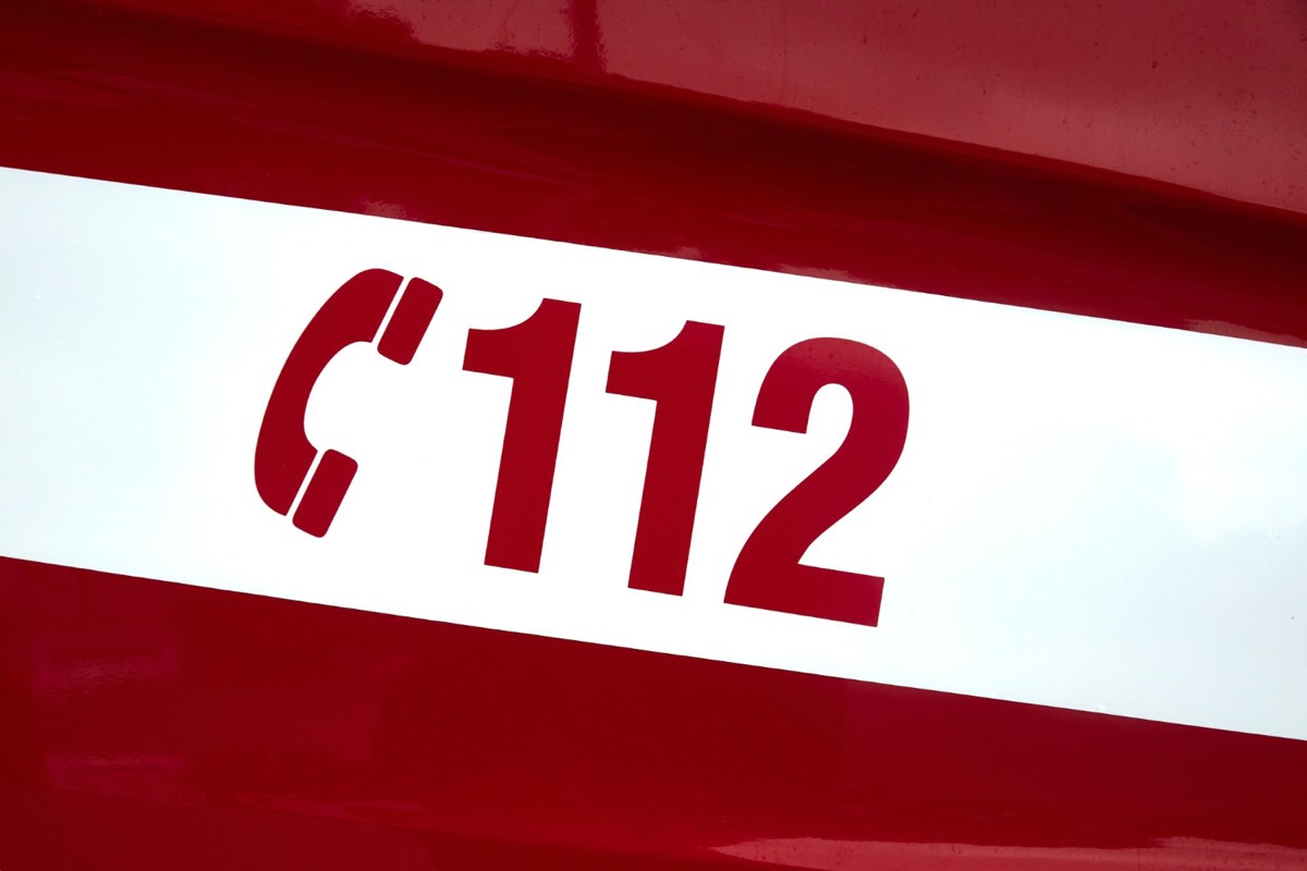 Rettungsfahrzeug mit Notruf 112 Aufschrift auf rotem Hintergrund