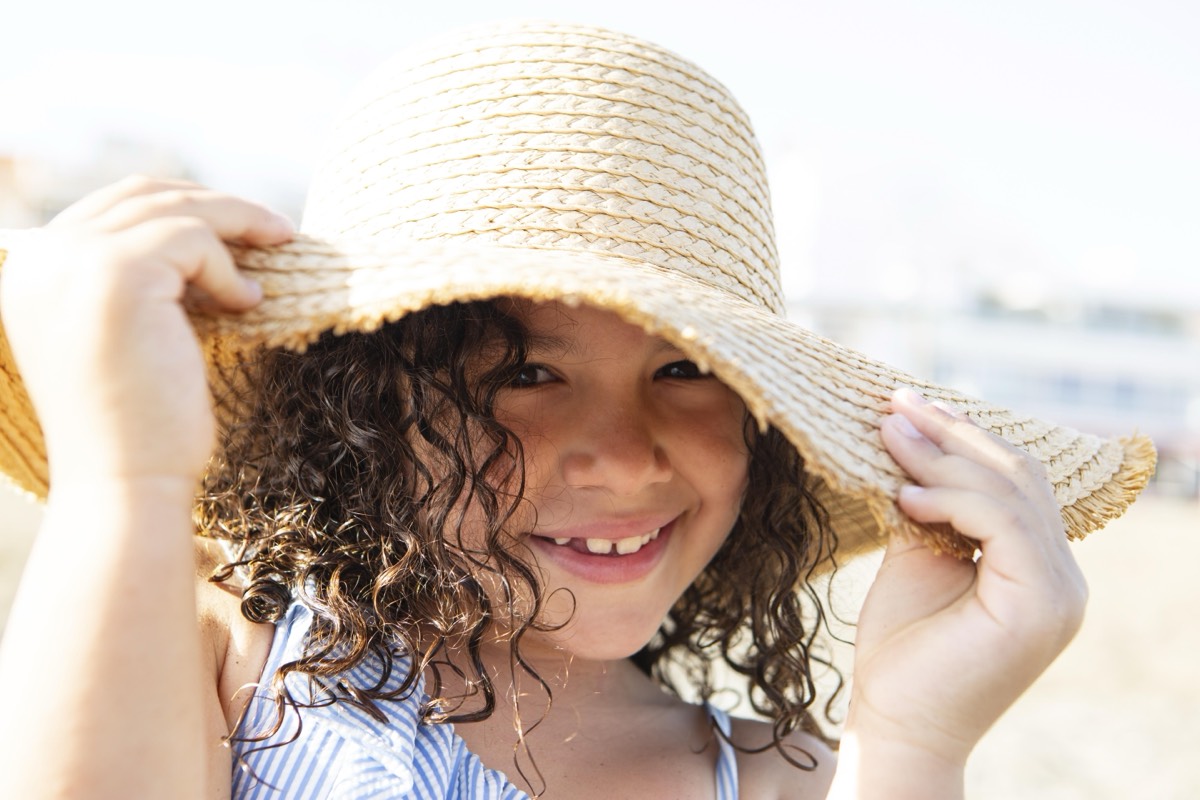 Kind mit Sonnenhut am Strand – Sonnenschutz und Hitzeschutz für Kinder